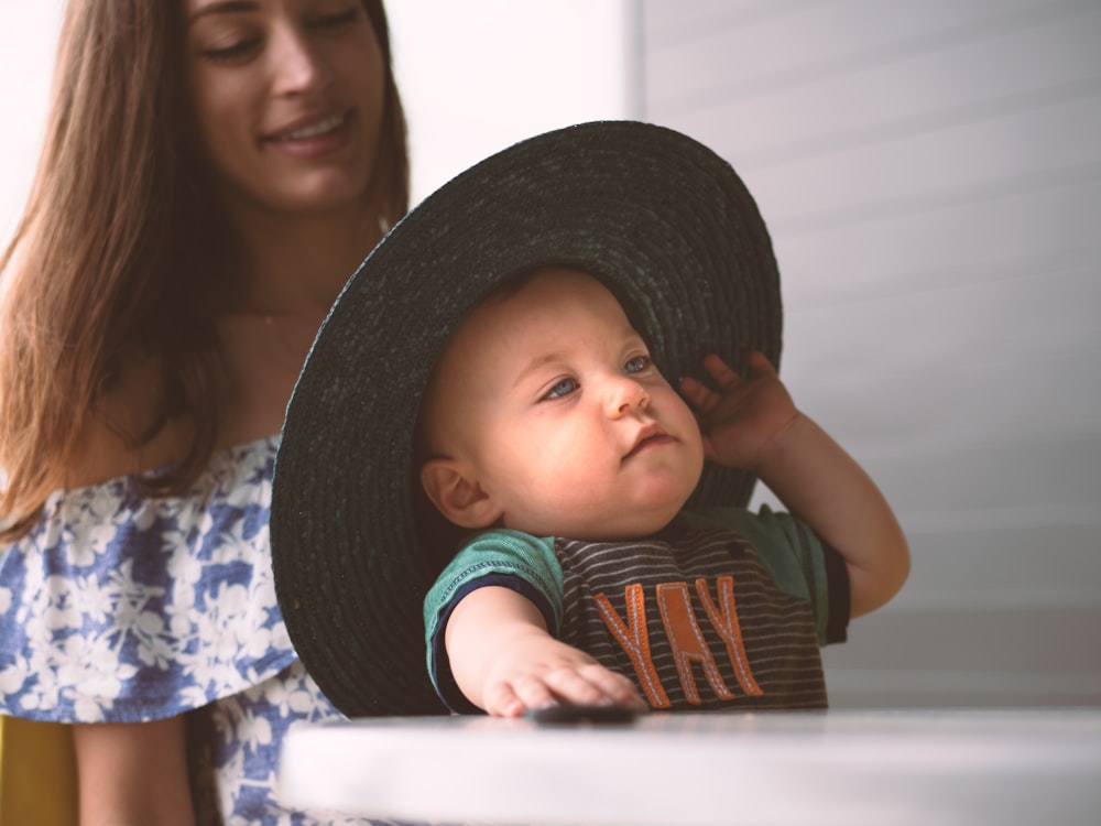 woman in blue and white floral shirt carrying baby in blue and white shirt