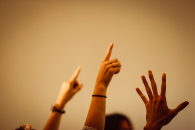 Hands raised in a classroom symbolizing democratic participation and engagement.
