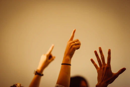 A vibrant group of left-handed people joyfully raising their hands together in solidarity.