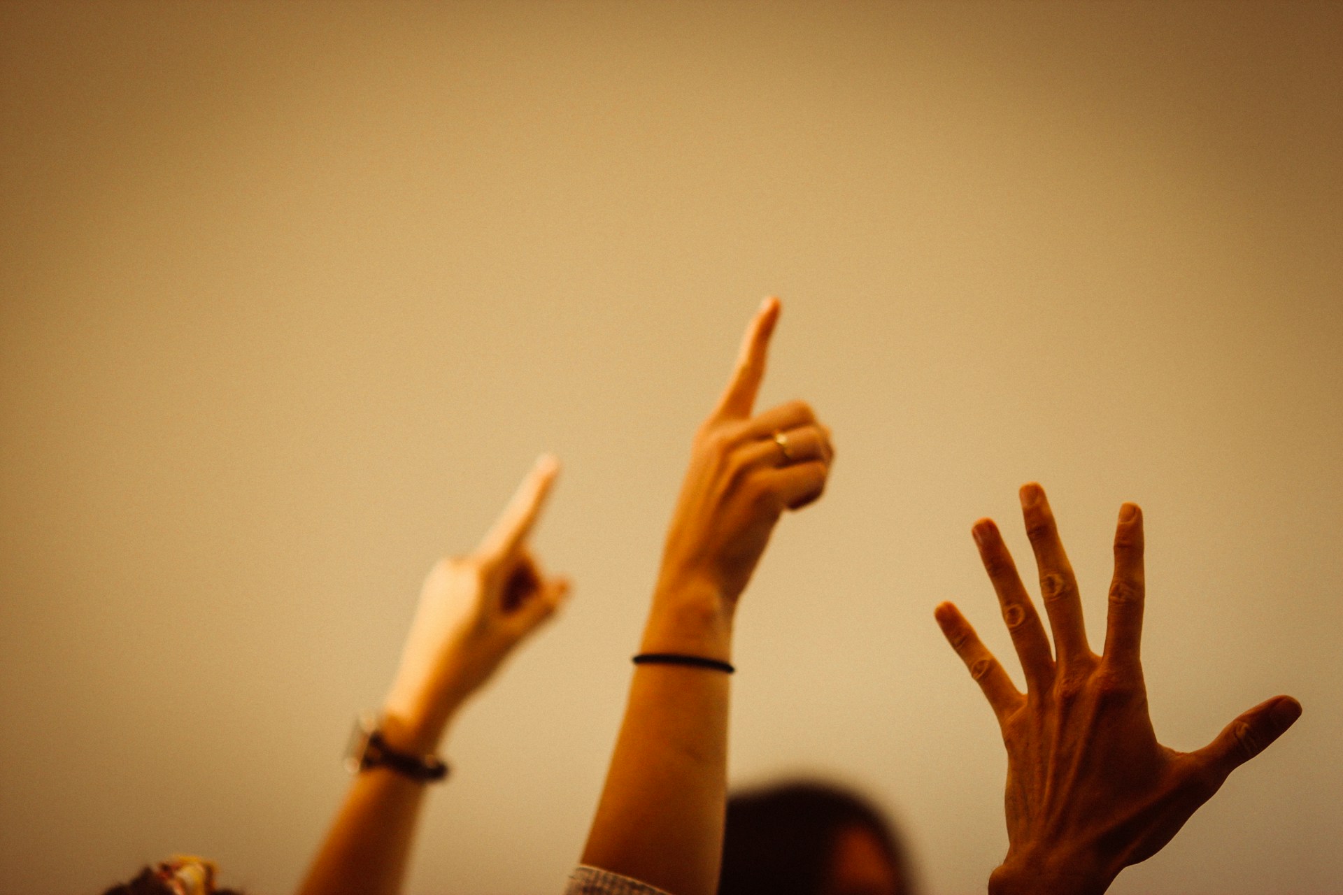 person in black long sleeve shirt raising right hand