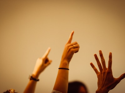 person in black long sleeve shirt raising right hand