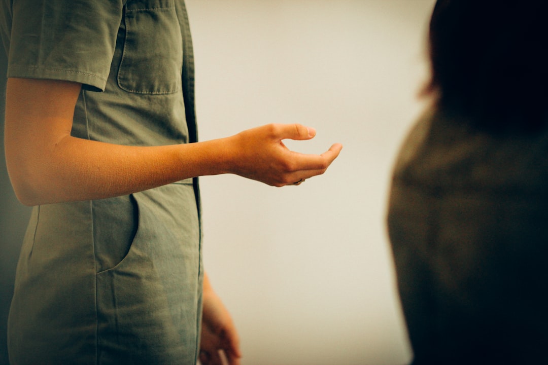 person in gray shirt holding white wall