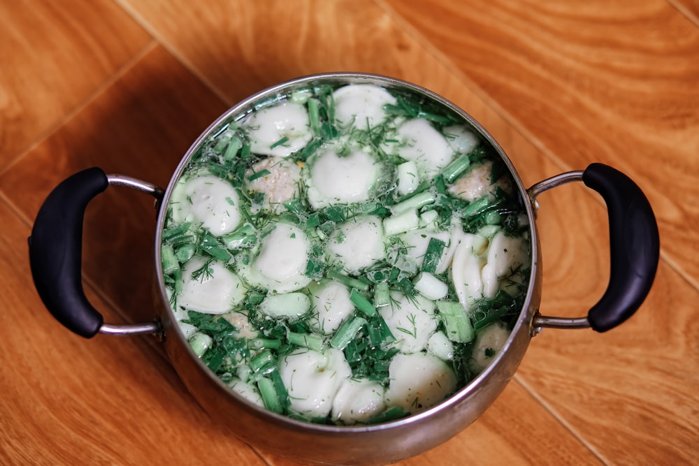 흰색과 녹색 수프를 곁들인 스테인리스 요리 냄비