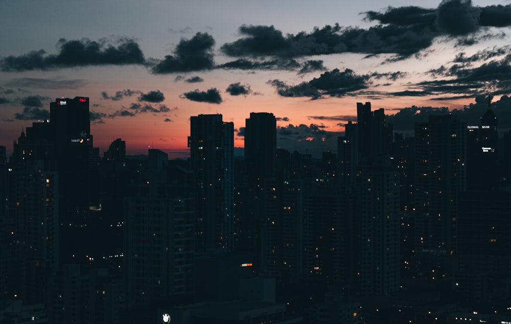 city skyline under cloudy sky during sunset