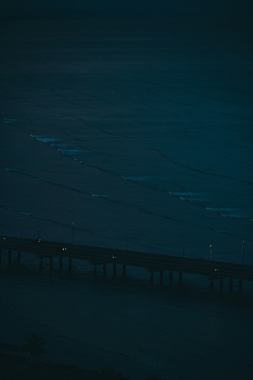 black wooden dock on blue body of water during night time