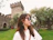 Smiling woman standing in front of Bran Castle on a sunny day.