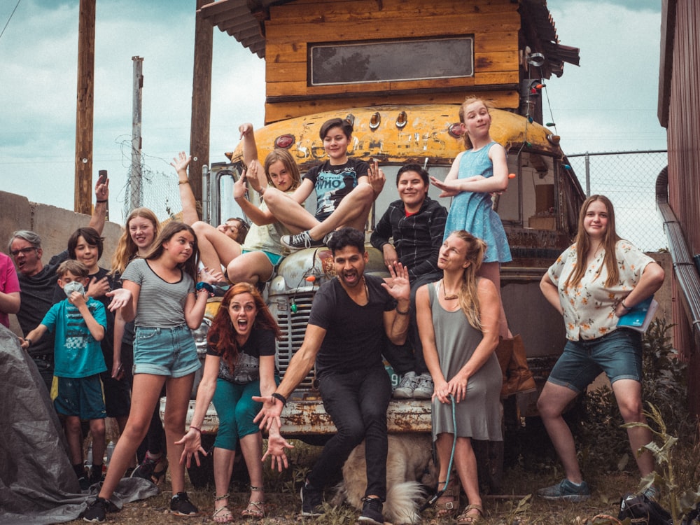 group of people standing near brown wooden house during daytime