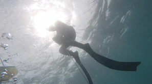 Smiling diver surfacing with the sun setting over Bursa’s sea horizon.