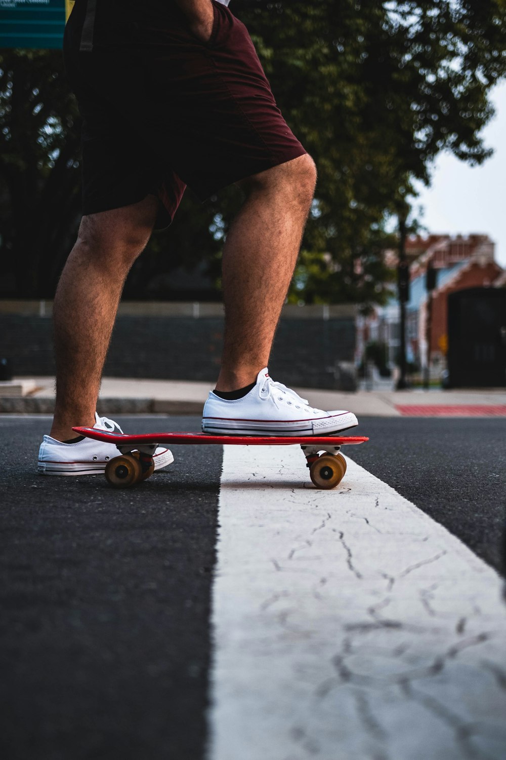 Persona in scarpe da ginnastica Nike bianche e rosse che cavalcano lo skateboard arancione