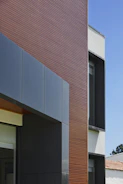Front view of a modern storefront with sleek ACM facade in dark blue tones.