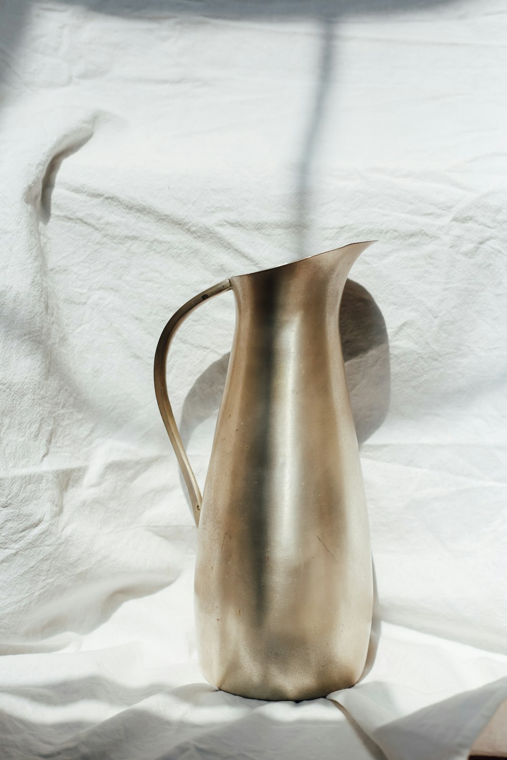stainless steel pitcher on white textile