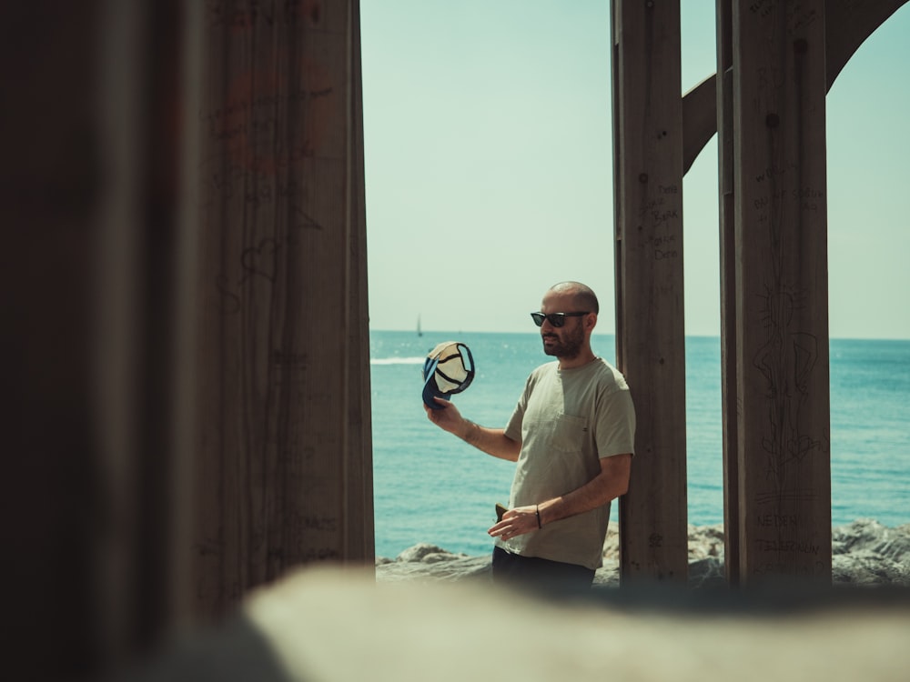 man in white crew neck t-shirt and blue denim jeans standing on white sand during