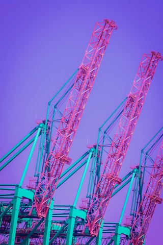 red metal crane under blue sky