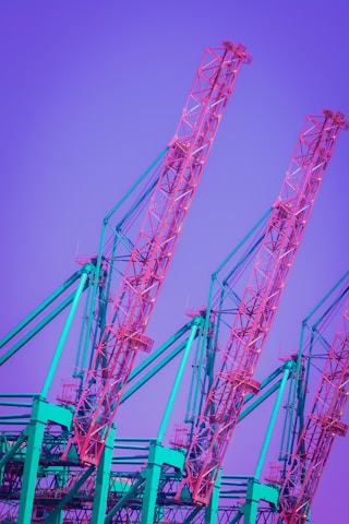 red metal crane under blue sky