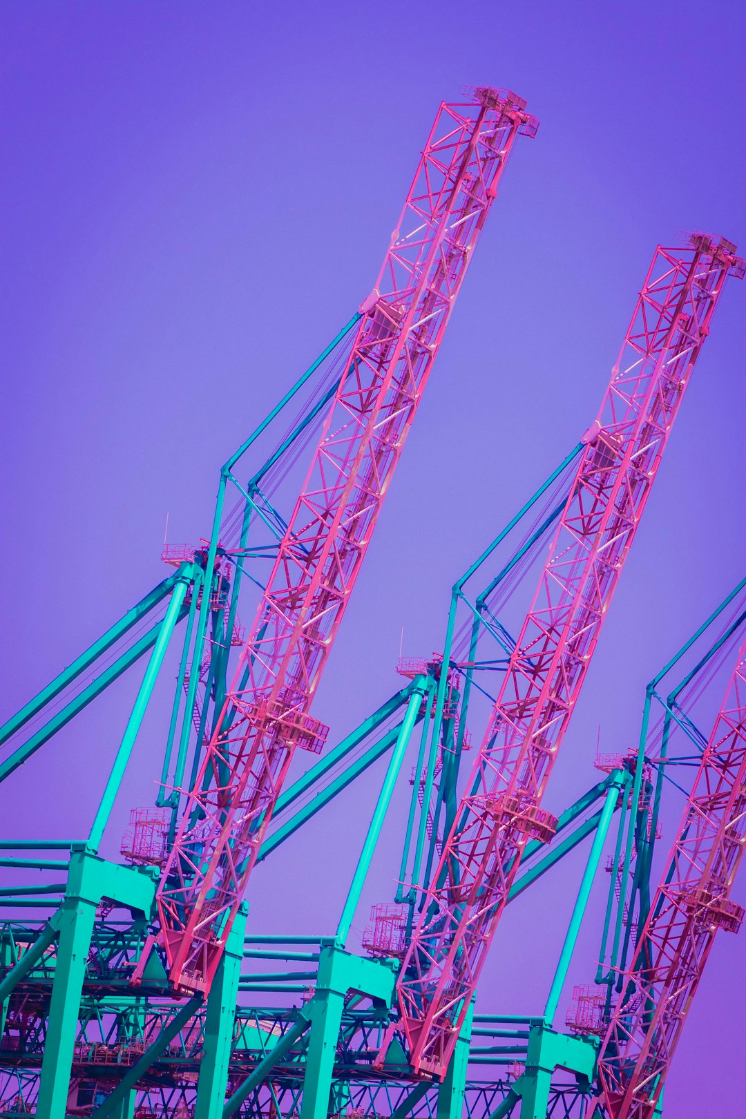 red metal crane under blue sky