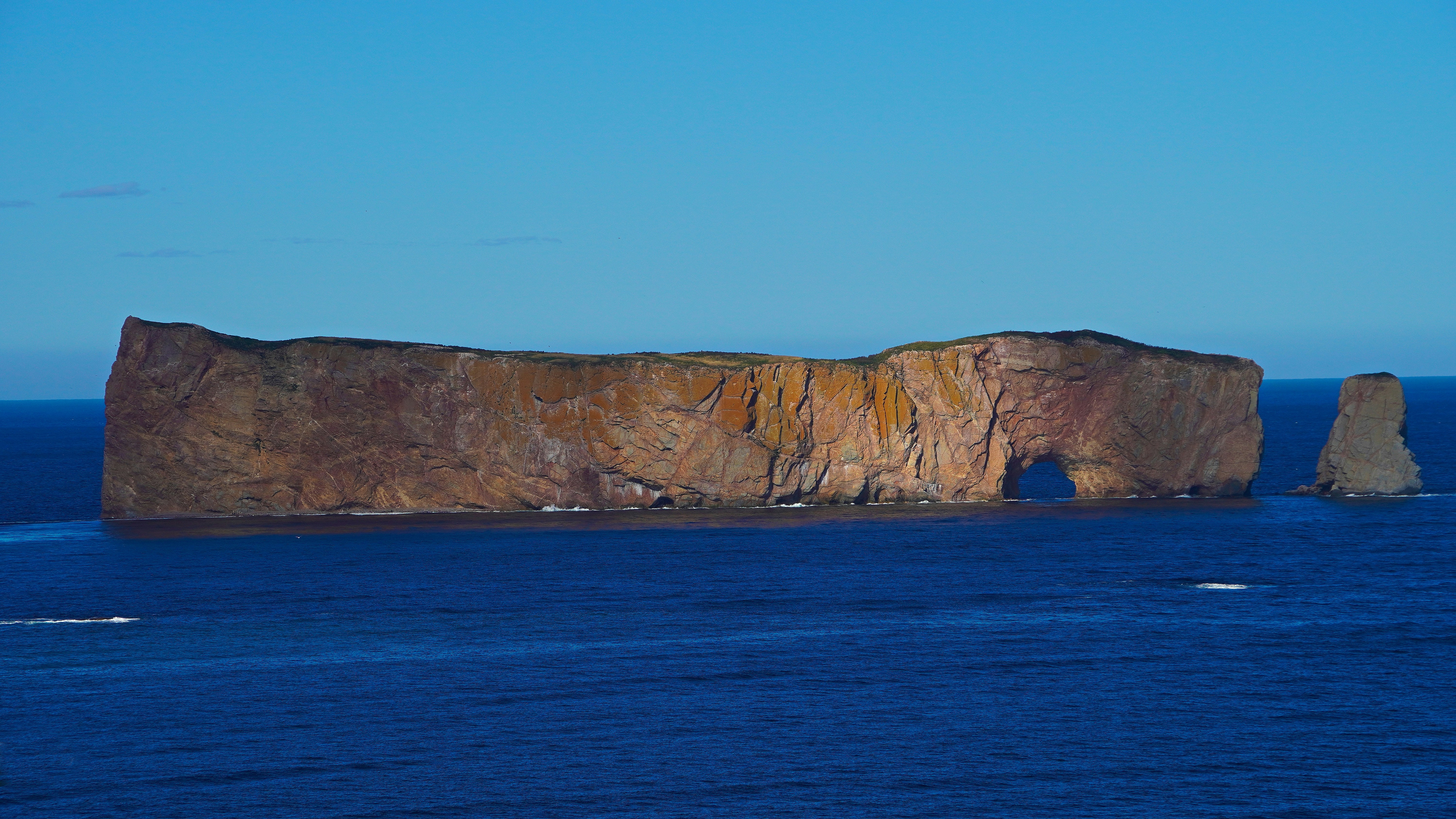 brown rock formation on blue sea under blue sky during daytime