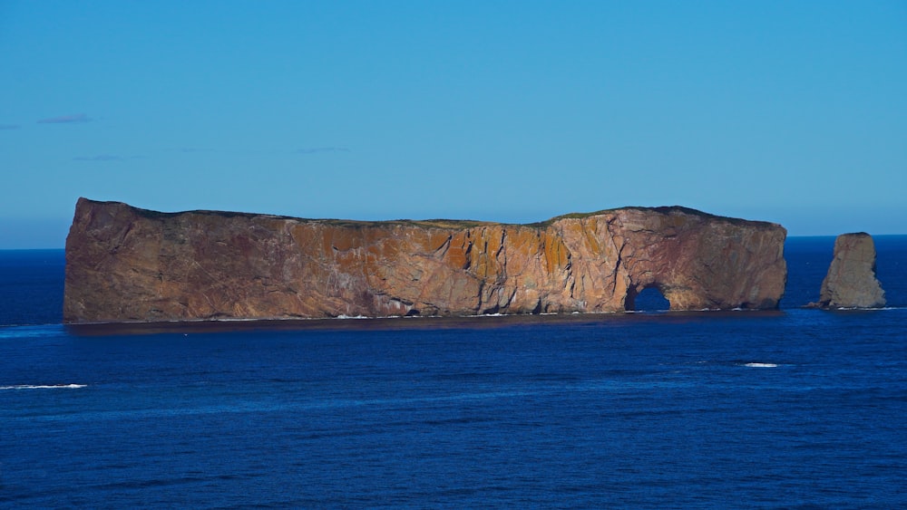 brown rock formation on blue sea under blue sky during daytime