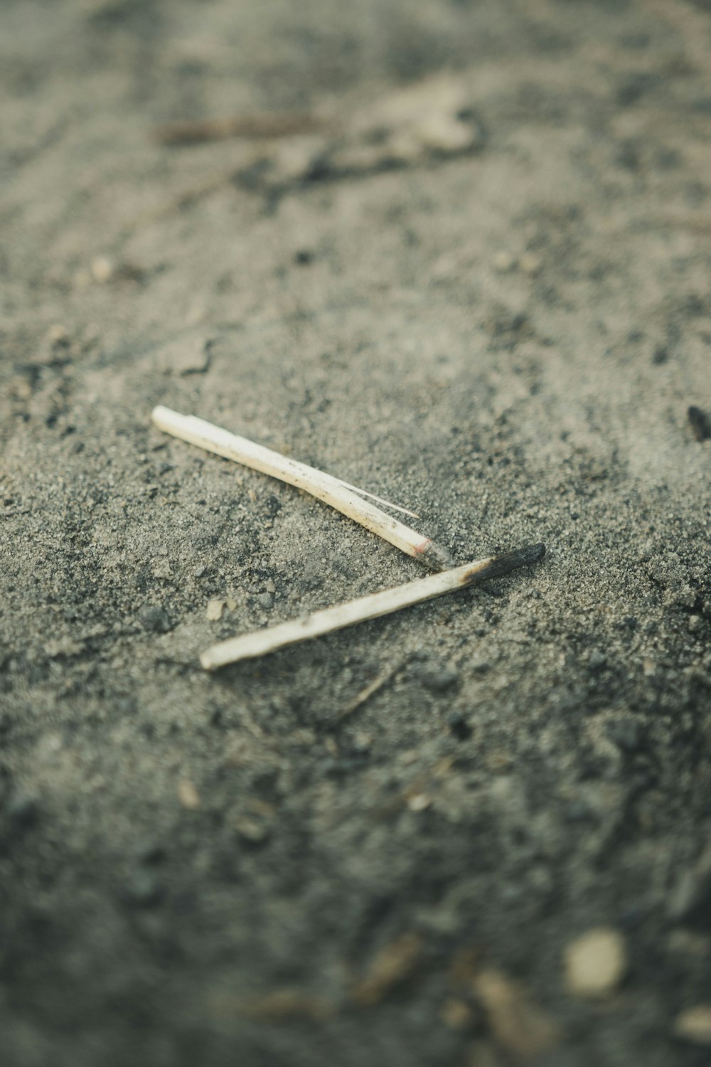 white and brown cigarette stick on gray concrete floor