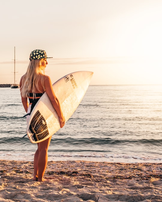 woman in black bikini holding surfboard standing on beach during daytime in Byron Bay Australia