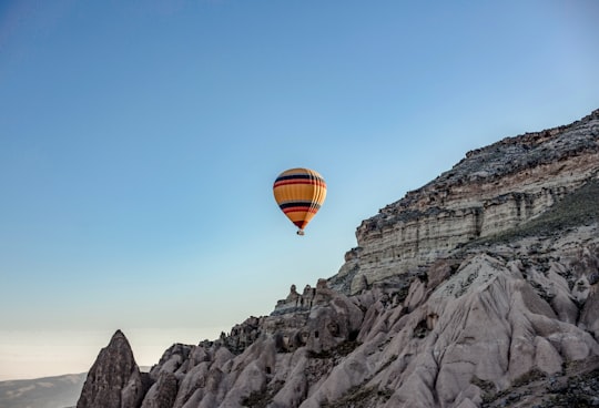 hot air balloon flying over rocky mountain during daytime in Kapadokya Turkey