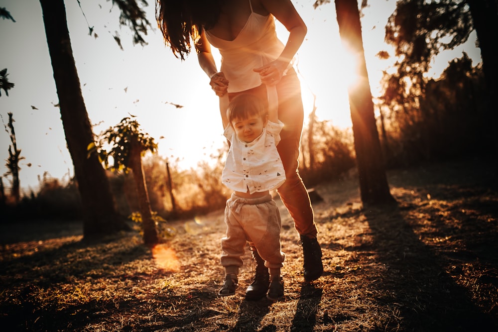 woman in white tank top and white shorts standing on forest during daytime