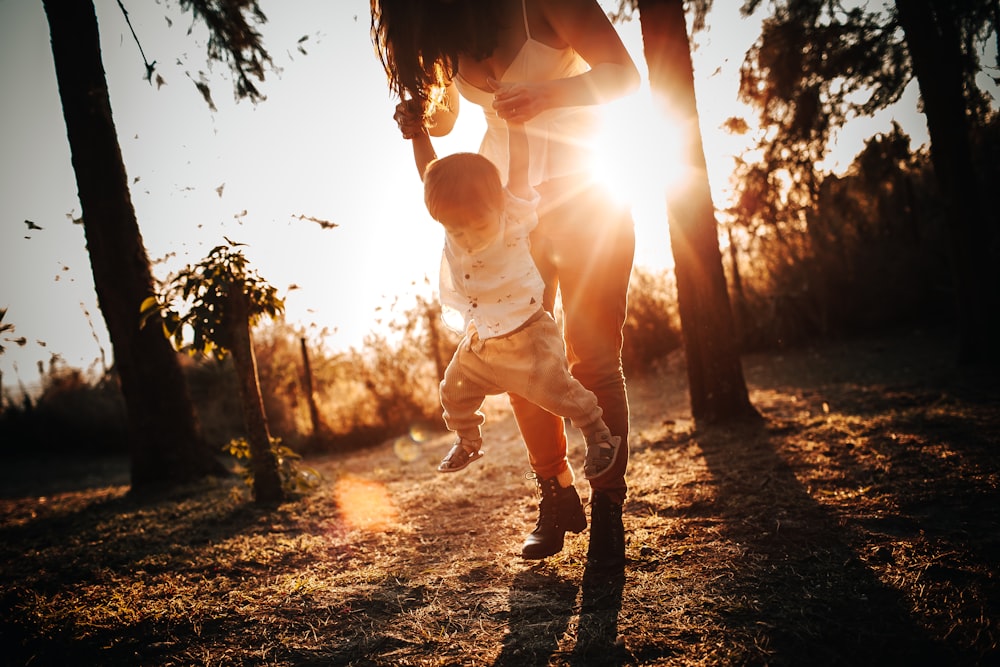 woman in white tank top and black pants standing under tree during daytime