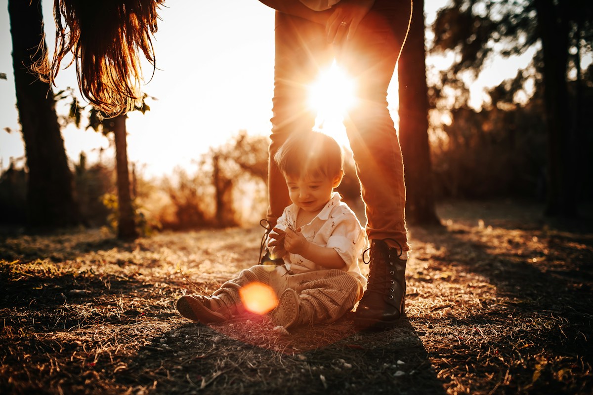 Young girl in a white shirt sitting on the ground, symbolizing kindergarten readiness and the start of school routines.