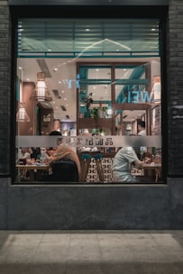 Cozy interior of the gdenz resto’ba with warm lighting and happy diners.