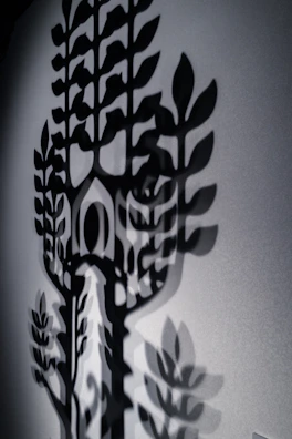 An artistic shot of shadows cast by tree branches on a wall.