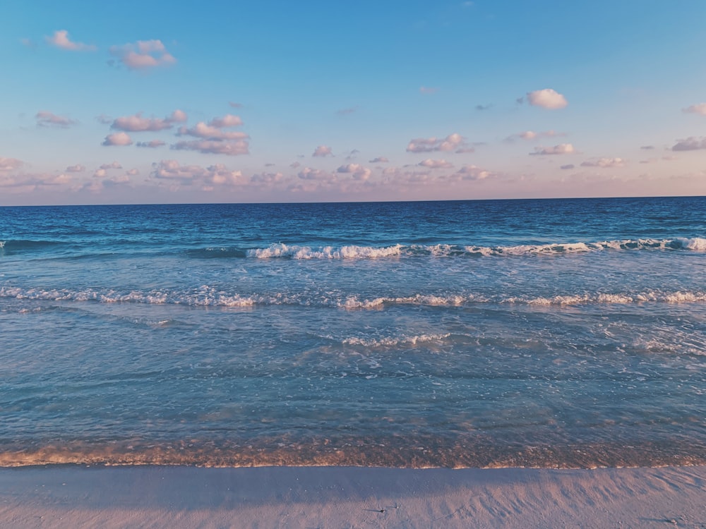 Onde del mare che si infrangono sulla riva durante il giorno