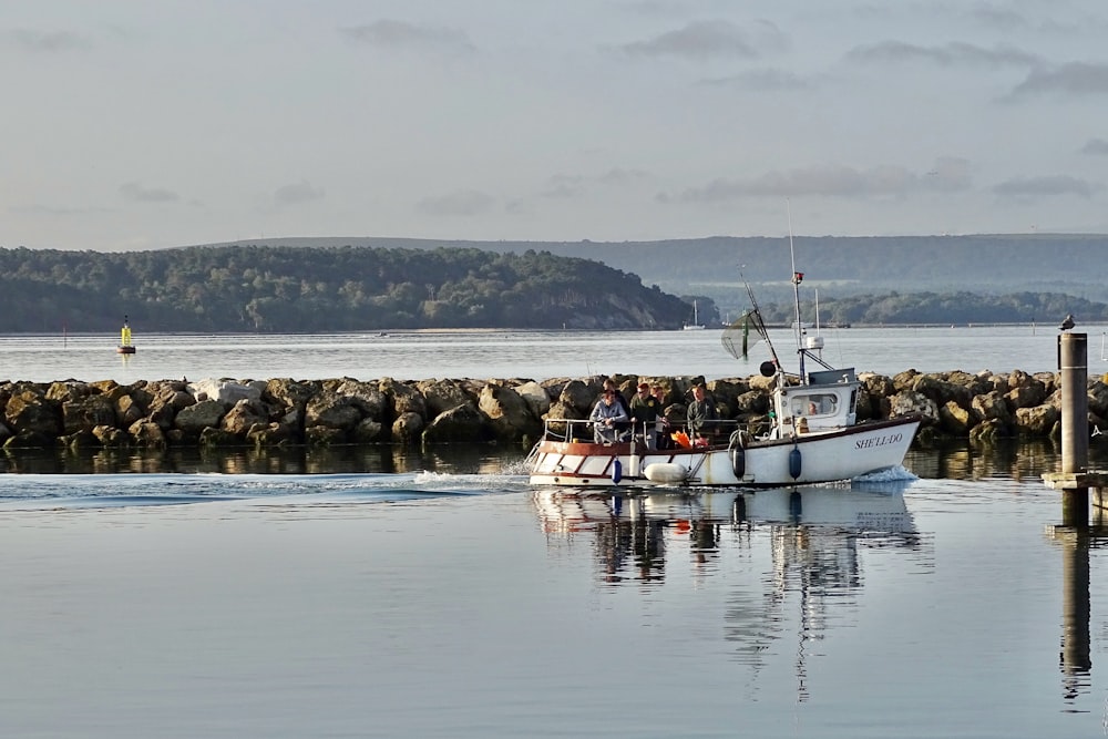 personnes à cheval sur un bateau blanc sur la mer pendant la journée