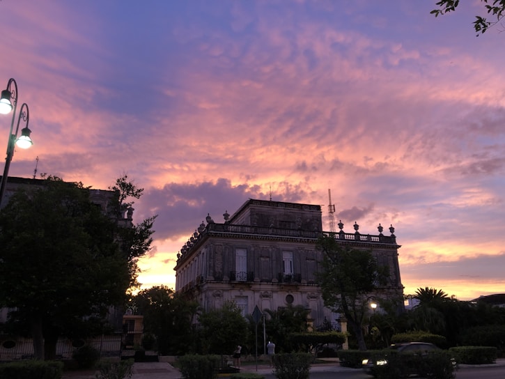 A vibrant street view of a historic building in Malang during sunset.