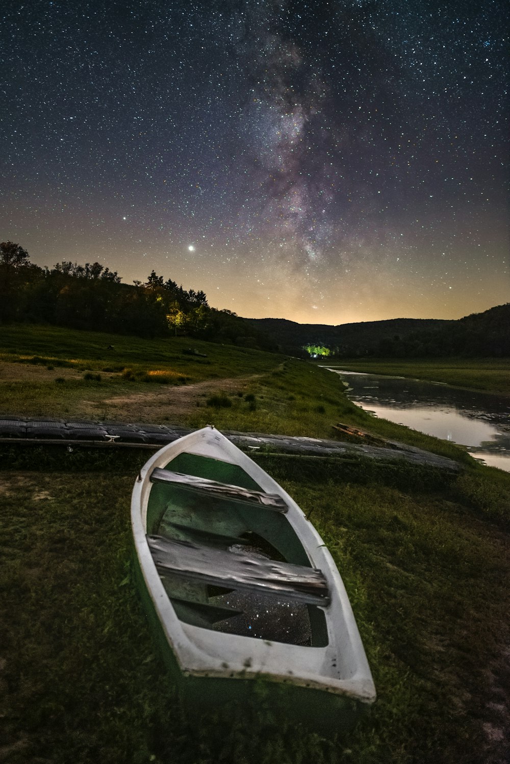 white canoe on green grass field near lake during night time