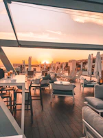 Outdoor patio area with comfortable seating and a view of the sunset over the nearby hills.