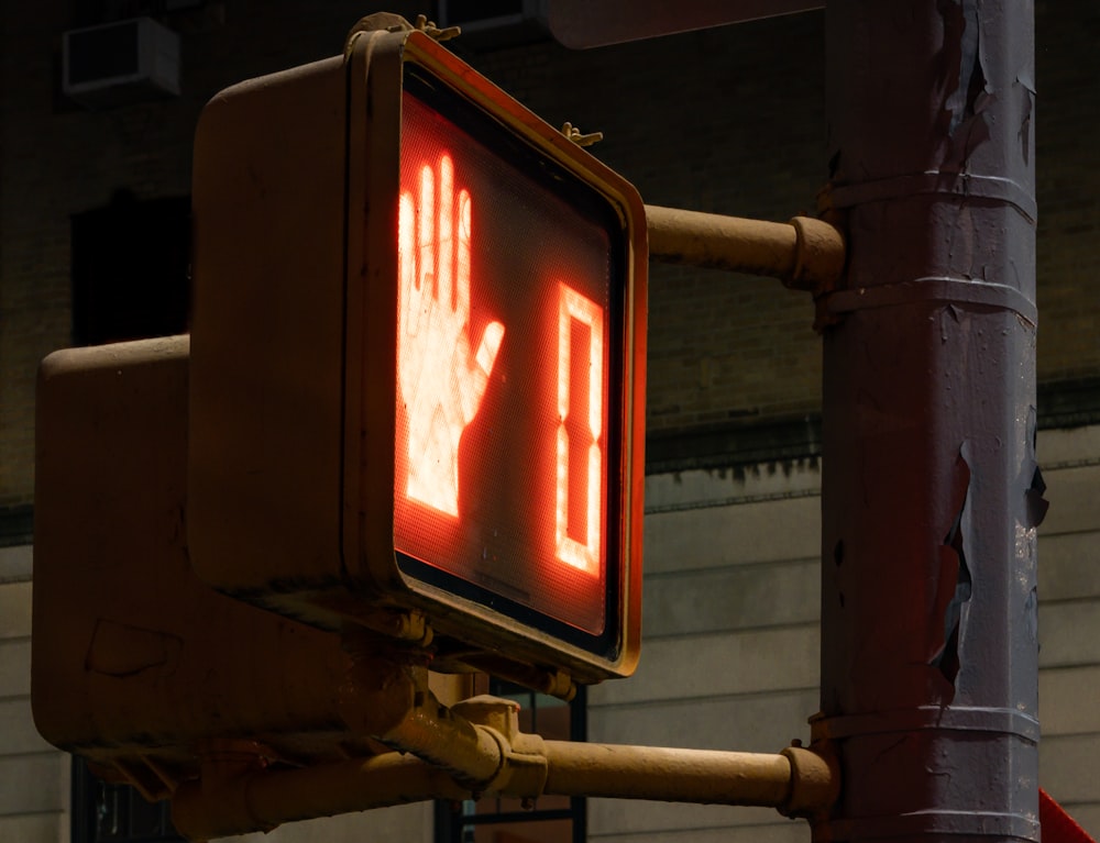 uma luz de parada com um sinal de mão sobre ele