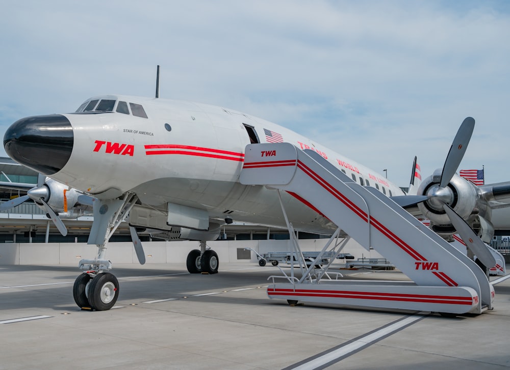 white and red passenger plane on airport during daytime