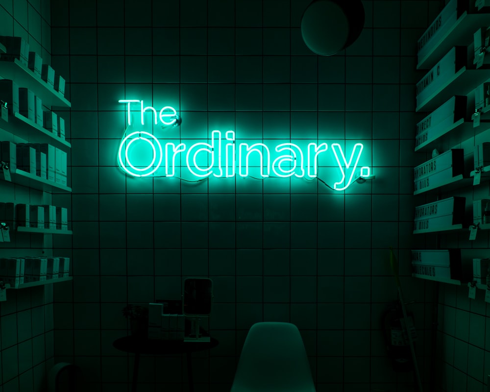 a green neon sign that reads the ordinary