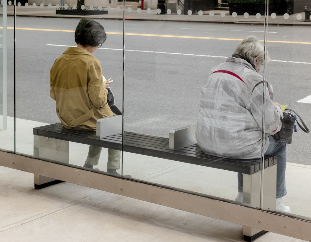 Mujer con chaqueta gris de pie junto a la ventana de vidrio