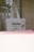 A tote bag hanging on a metal rack, featuring the text 'tinder is not' and a small sign with a price tag of 3.99 attached to it. The photo has an overexposed strip at the bottom, giving it an artistic, vintage feel.