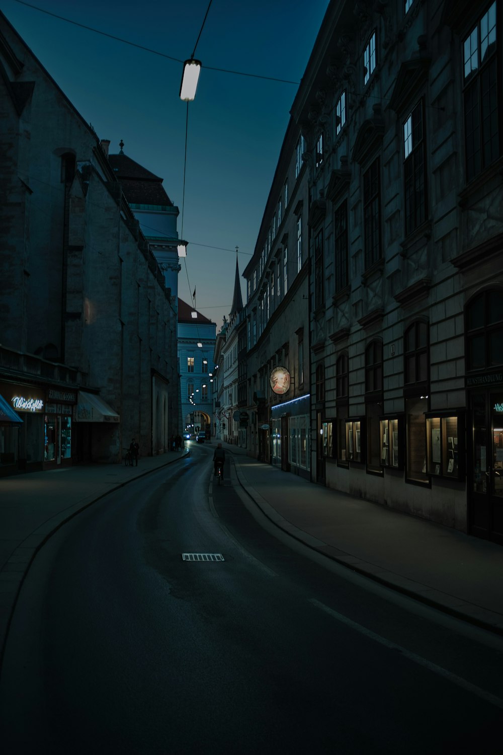 empty road between high rise buildings during night time