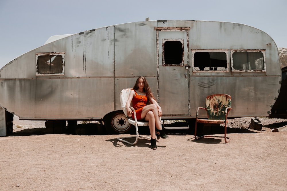 woman in red shirt sitting on brown wooden chair