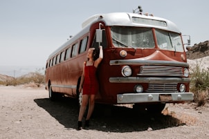 red and white bus on brown sand during daytime