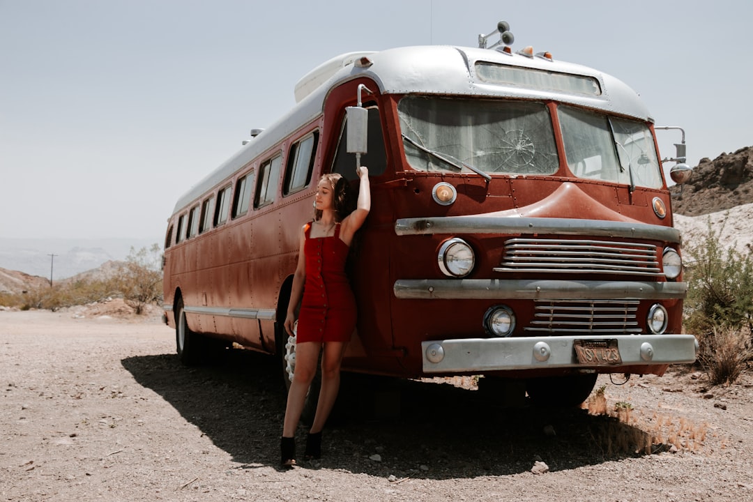 red and white bus on brown sand during daytime