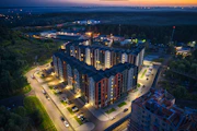 Evening view of a completed apartment complex glowing warmly under soft lights.