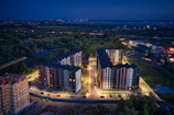 Night view of a grand residential complex with illuminated facades and landscaped gardens