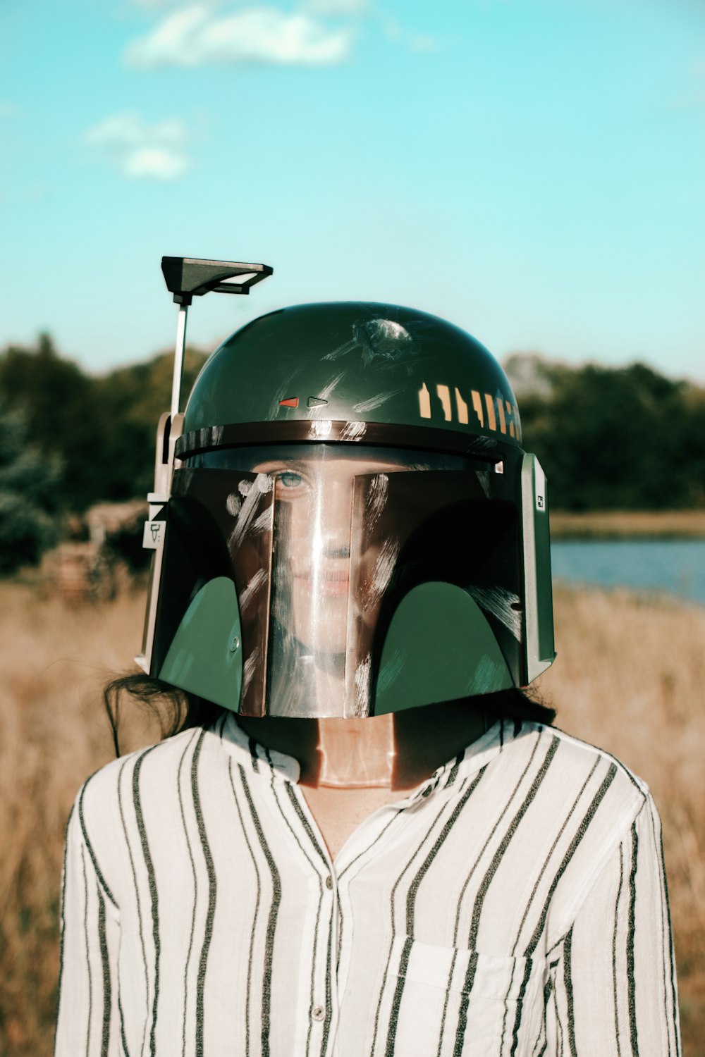 person in black helmet and white and black stripe shirt