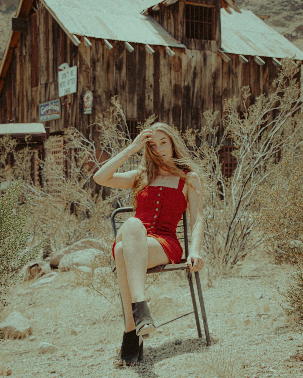 woman in red tank top and black shorts sitting on brown wooden ladder
