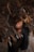 A person with closed eyes is surrounded by dense, dark foliage, creating a serene atmosphere. The leaves have a rich, brownish color contrasting with the smooth texture of the individual's skin. The composition gives a sense of being intertwined with nature.