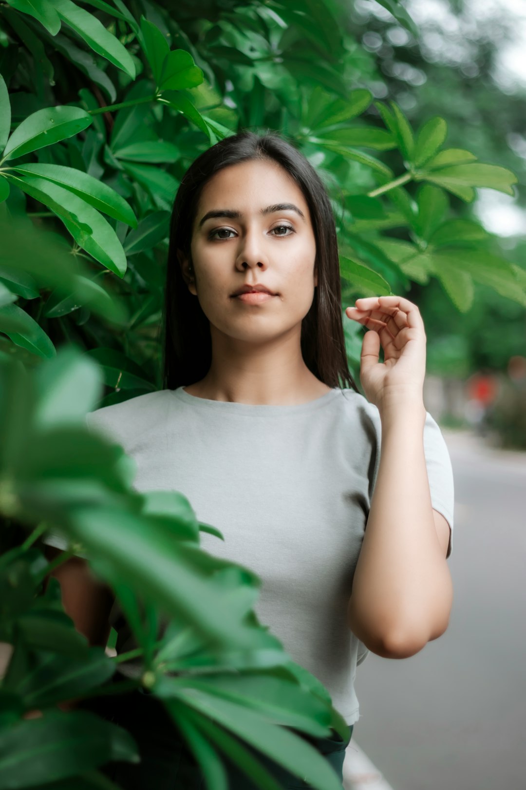 woman in white crew neck t-shirt standing near green plant during daytime