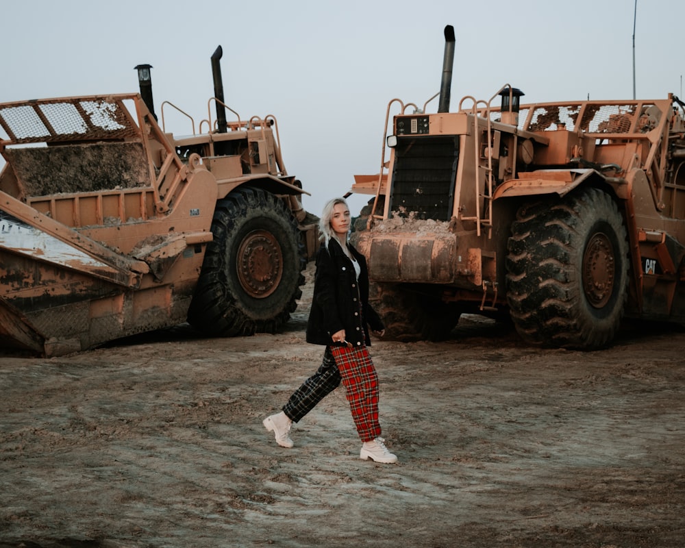 a woman walking in front of a large bulldozer